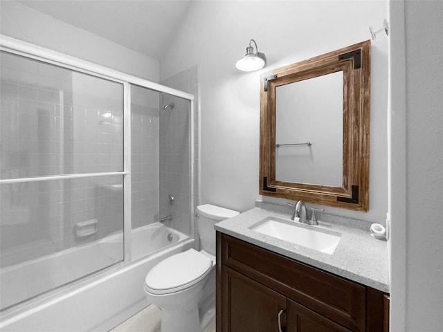 bathroom featuring toilet, combined bath / shower with glass door, vaulted ceiling, and vanity