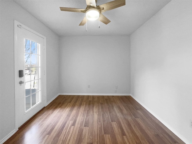 unfurnished room with dark wood-style floors, ceiling fan, and baseboards