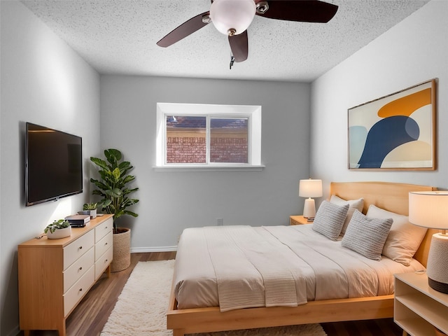 bedroom featuring ceiling fan, a textured ceiling, and wood finished floors