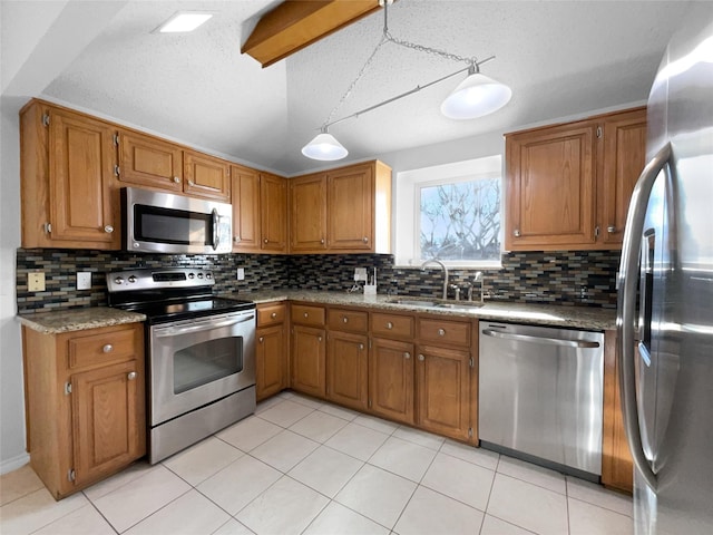 kitchen with stainless steel appliances, vaulted ceiling, brown cabinets, and a sink