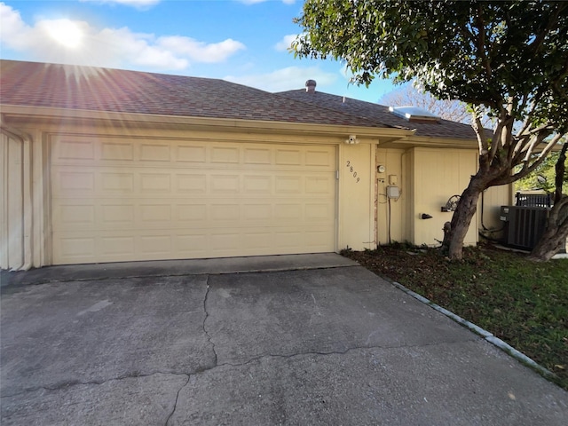 garage with concrete driveway and central AC unit