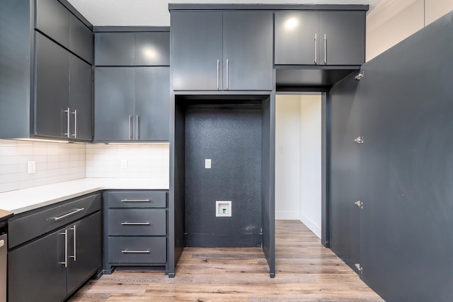 kitchen with tasteful backsplash, light countertops, gray cabinetry, light wood-style floors, and modern cabinets