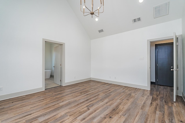 empty room featuring wood finished floors, visible vents, and baseboards