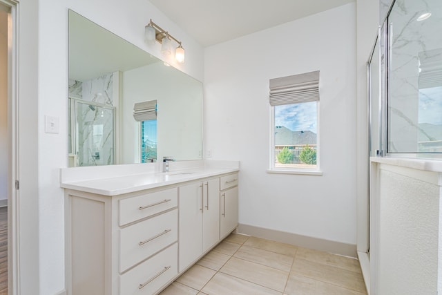 bathroom featuring baseboards, a marble finish shower, vanity, and tile patterned floors