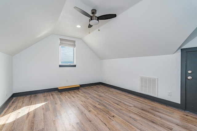 bonus room with lofted ceiling, wood finished floors, visible vents, and baseboards