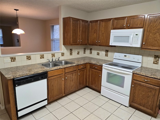 kitchen featuring pendant lighting, backsplash, a sink, a textured ceiling, and white appliances