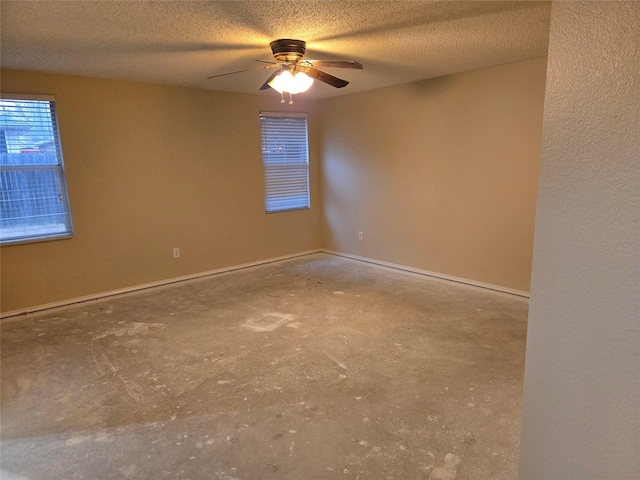 unfurnished room featuring baseboards, a ceiling fan, and a textured ceiling