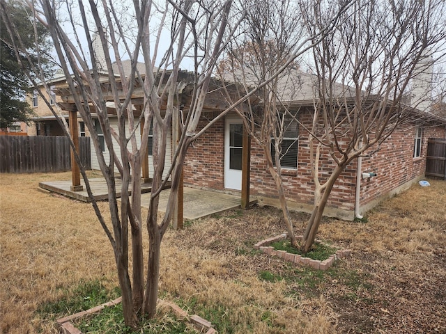 back of property featuring a patio area, a yard, fence, and brick siding