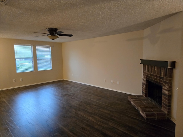 unfurnished living room with dark wood-style floors, a brick fireplace, baseboards, and a ceiling fan