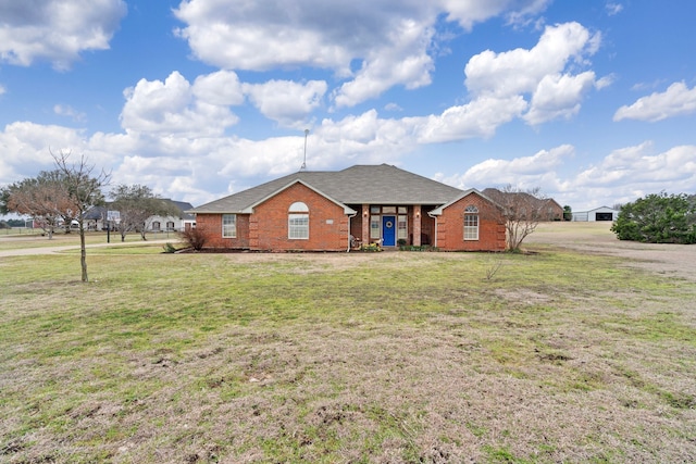 view of front facade with a front yard and brick siding