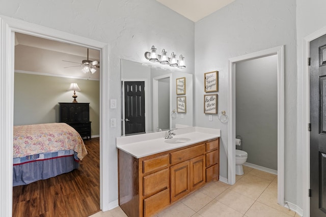 bathroom with ceiling fan, tile patterned flooring, toilet, vanity, and ensuite bath