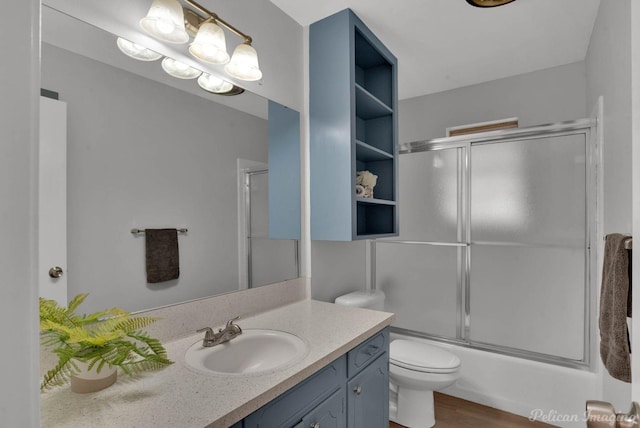 bathroom featuring shower / bath combination with glass door, vanity, toilet, and wood finished floors