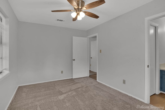 unfurnished bedroom with a ceiling fan, carpet, visible vents, and baseboards