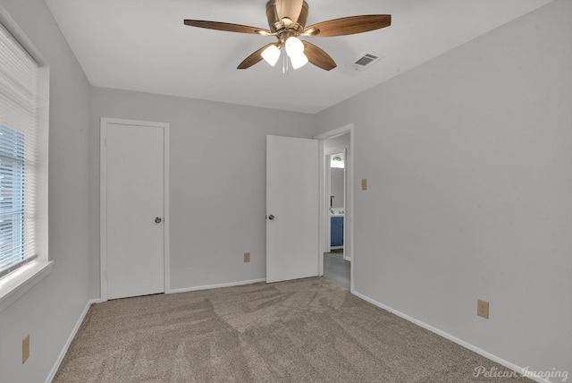 unfurnished bedroom with a ceiling fan, visible vents, baseboards, and carpet flooring