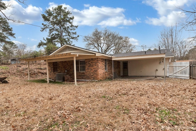 back of house featuring brick siding, fence, and central air condition unit