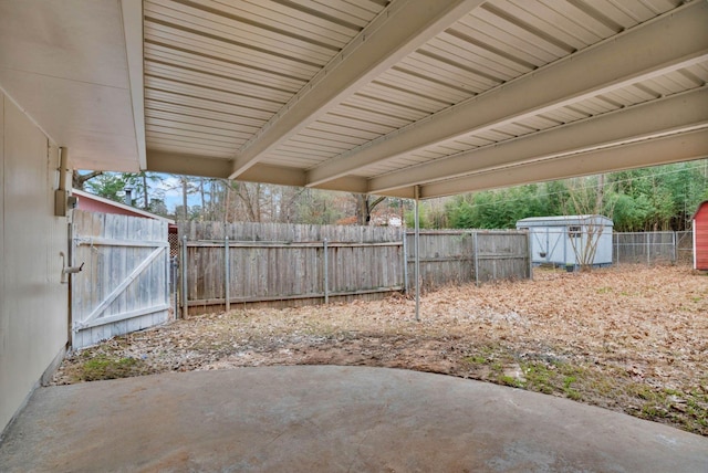 view of patio / terrace with fence, a storage unit, and an outbuilding