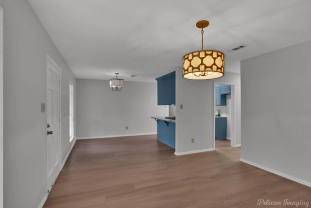 interior space with visible vents, baseboards, and wood finished floors