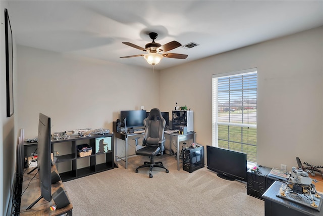 home office featuring carpet floors, visible vents, and ceiling fan