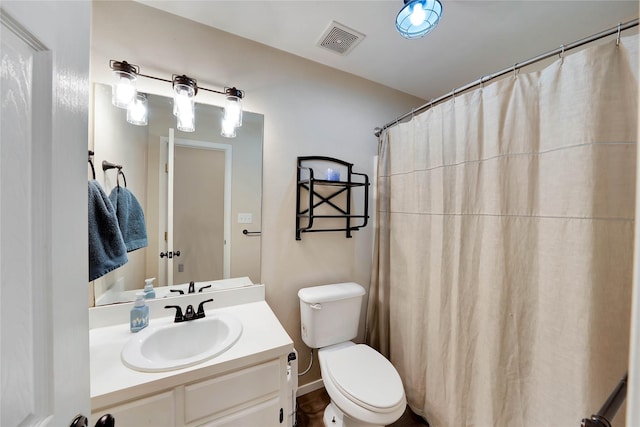 bathroom with curtained shower, visible vents, vanity, and toilet