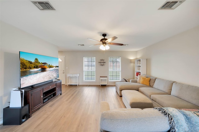 living area featuring light wood-style floors, visible vents, and ceiling fan