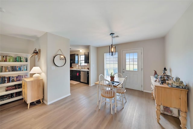 dining room featuring light wood-type flooring, visible vents, and baseboards