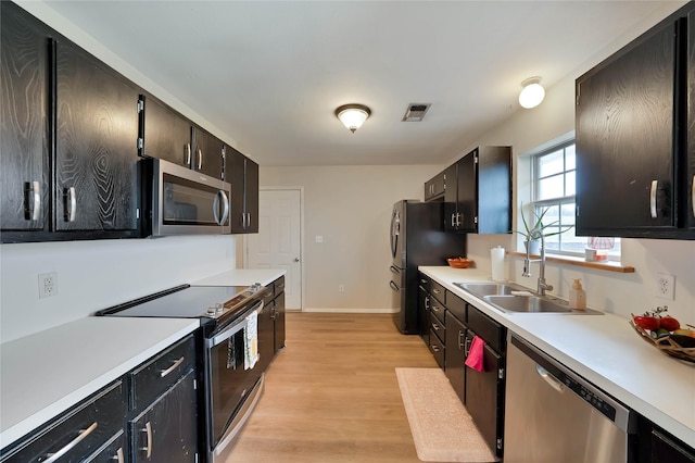 kitchen with stainless steel appliances, light countertops, visible vents, and a sink