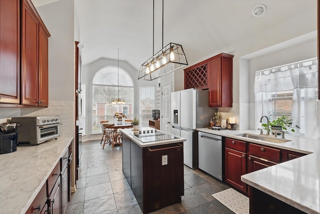 kitchen with reddish brown cabinets, lofted ceiling, a sink, a kitchen island, and dishwasher