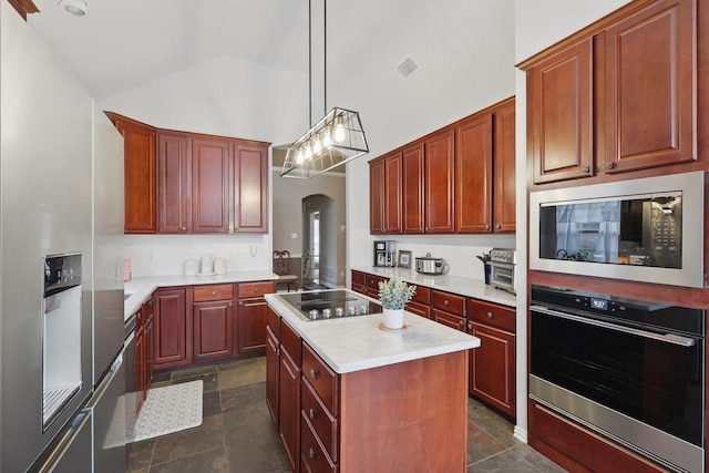 kitchen with visible vents, arched walkways, appliances with stainless steel finishes, a center island, and light countertops