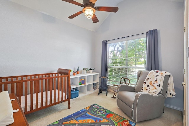 carpeted bedroom with lofted ceiling, ceiling fan, and a nursery area