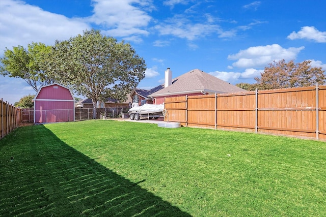 view of yard with an outbuilding, a barn, and a fenced backyard