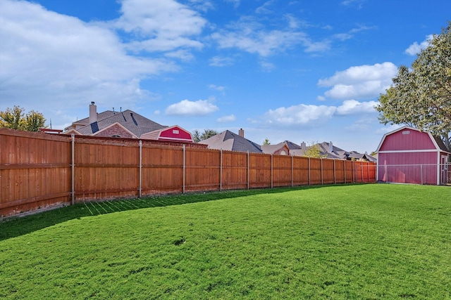 view of yard with an outdoor structure, a barn, and fence