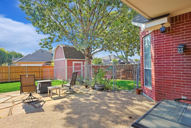 view of patio featuring an outbuilding, a fenced backyard, and a shed