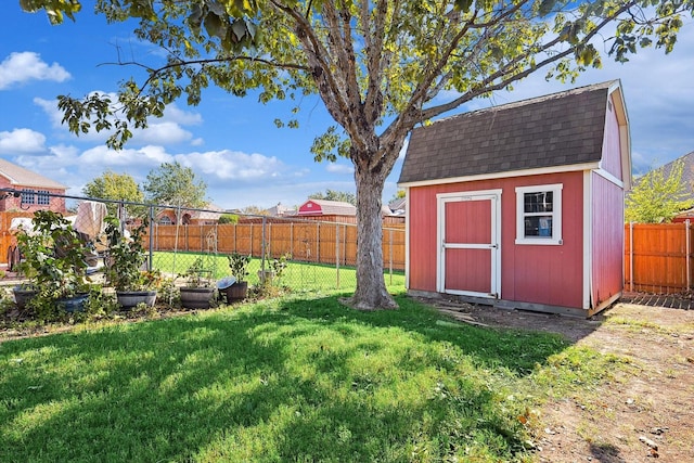 view of yard with a fenced backyard, an outdoor structure, and a shed