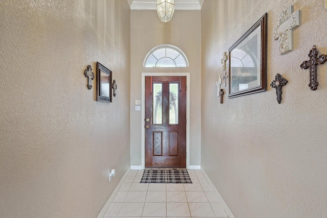 entryway with baseboards, a textured wall, and tile patterned floors