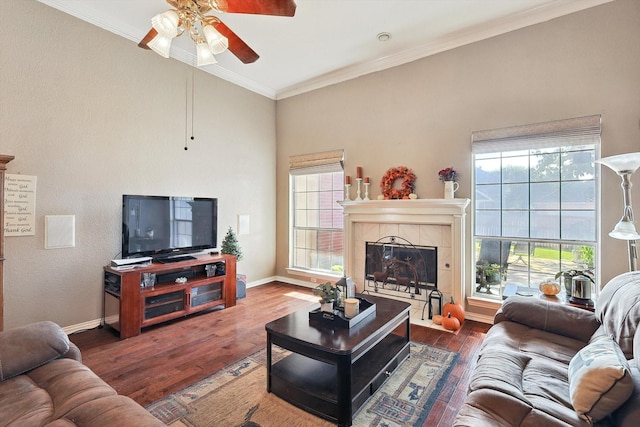 living area with baseboards, ornamental molding, wood finished floors, and a tile fireplace