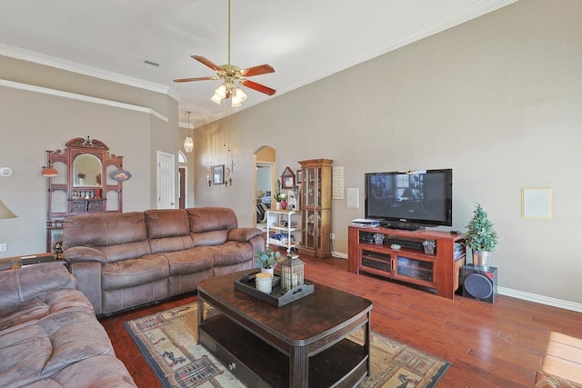 living room featuring baseboards, arched walkways, a ceiling fan, ornamental molding, and hardwood / wood-style floors