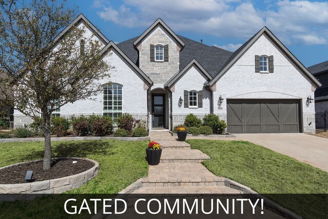 french country inspired facade featuring a front lawn, stone siding, a garage, brick siding, and concrete driveway