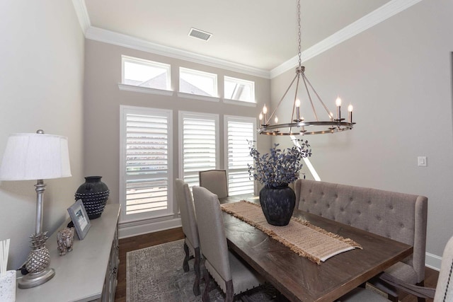 dining area with baseboards, visible vents, ornamental molding, dark wood-style flooring, and a chandelier