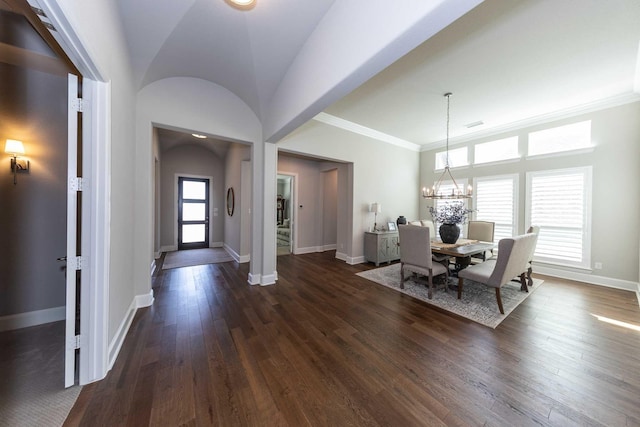 dining area with crown molding, dark wood-type flooring, an inviting chandelier, and baseboards