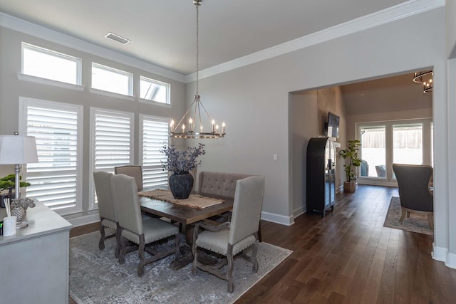 dining room with an inviting chandelier, a healthy amount of sunlight, crown molding, and visible vents