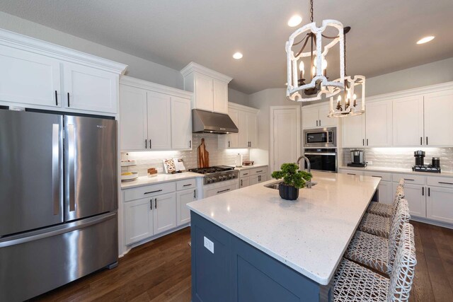 kitchen featuring visible vents, backsplash, appliances with stainless steel finishes, a sink, and under cabinet range hood