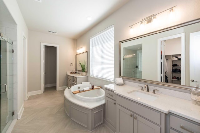 full bathroom with a stall shower, a garden tub, and a sink