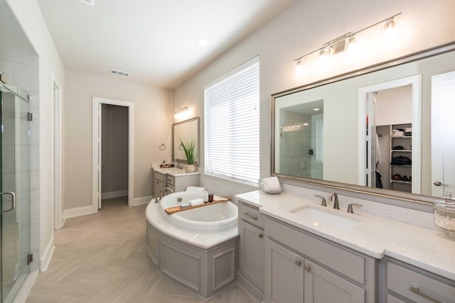 full bath with a garden tub, a sink, a stall shower, and two vanities