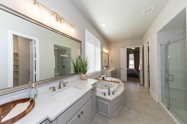 ensuite bathroom featuring vanity, ensuite bath, visible vents, a garden tub, and a stall shower