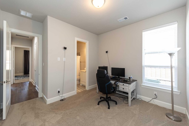 office space featuring carpet floors, visible vents, and baseboards