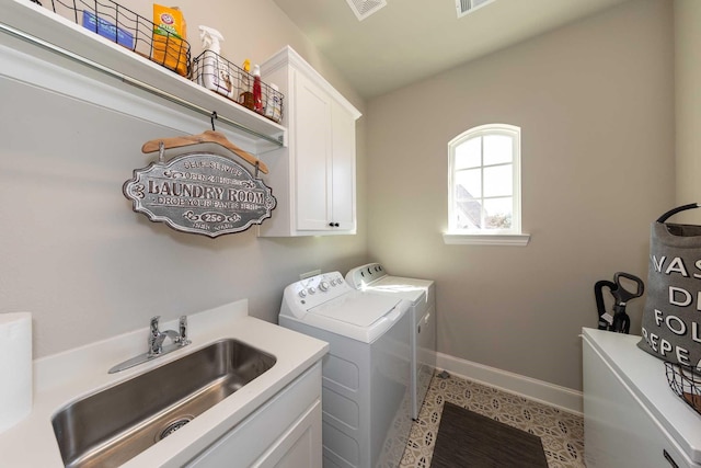 washroom featuring washing machine and dryer, a sink, visible vents, baseboards, and cabinet space