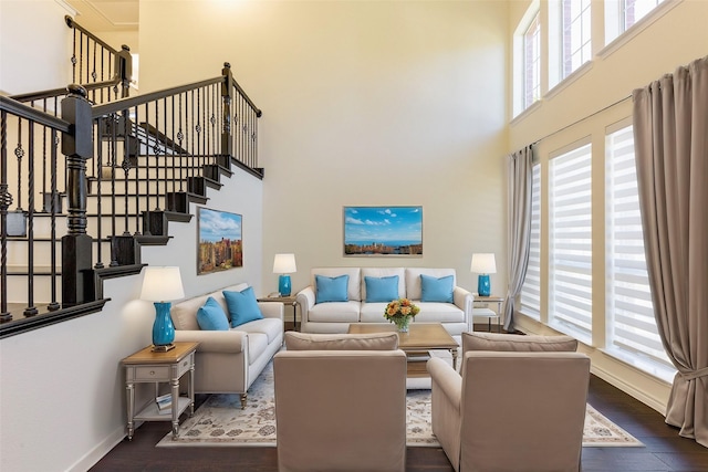 living room with a high ceiling, stairway, wood finished floors, and baseboards