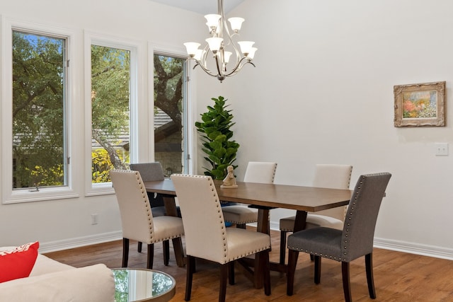 dining area featuring a notable chandelier, baseboards, and wood finished floors