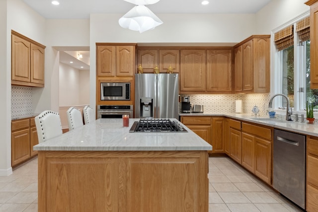 kitchen featuring stainless steel appliances, light tile patterned floors, a sink, and a kitchen island