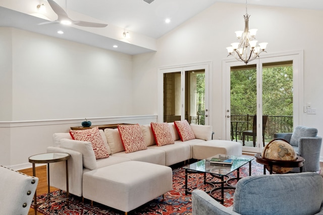 living area featuring lofted ceiling, recessed lighting, ceiling fan with notable chandelier, wood finished floors, and visible vents